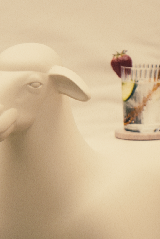 Goodnight Light SHEEP Black used as poolside side table with cocktail glass, outdoor pool setting
