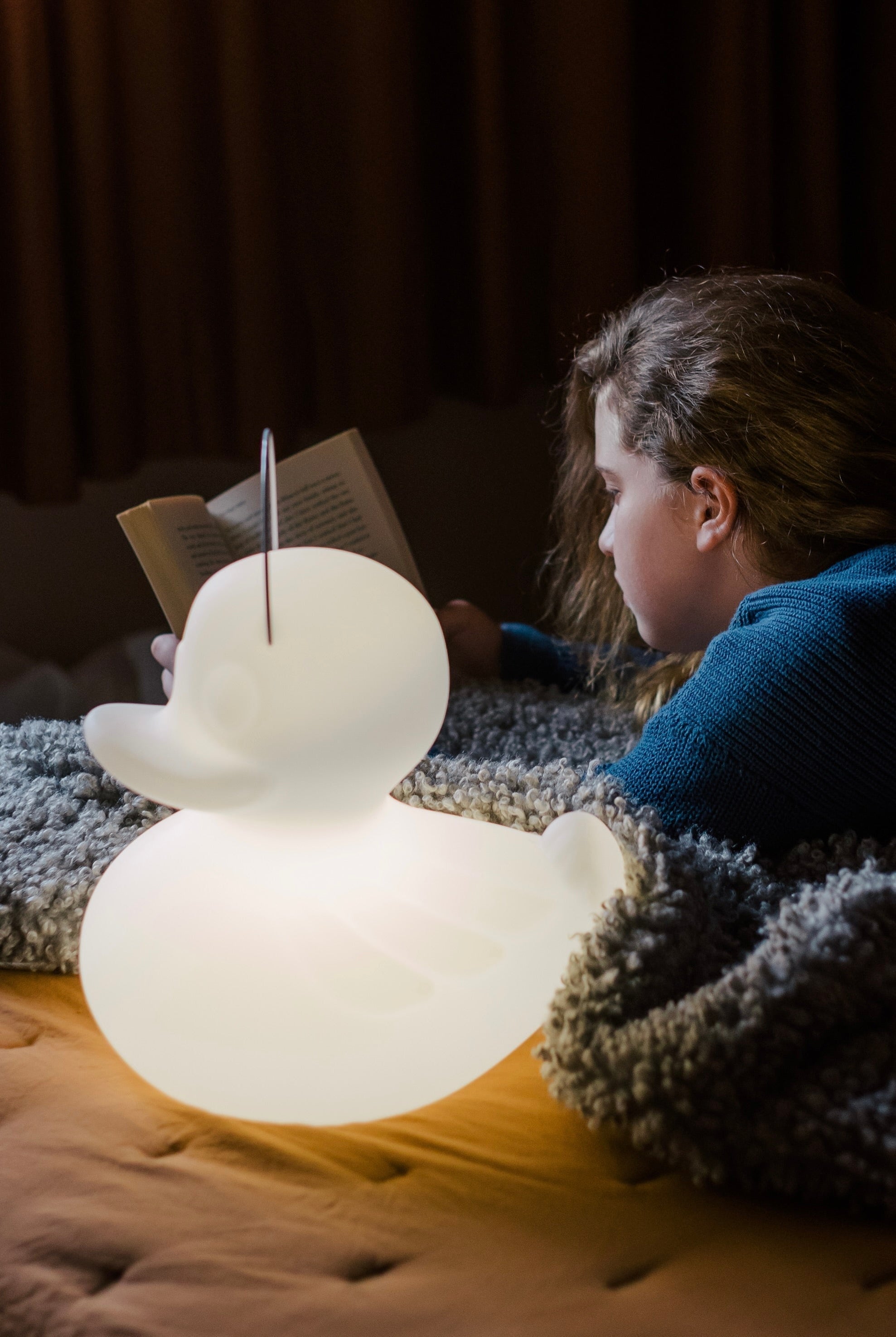 Goodnight Light lamp glowing softly in dark child's bedroom at night, dim night light setting