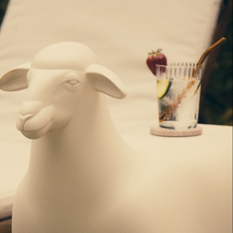 Goodnight Light SHEEP Black used as poolside side table with cocktail glass, outdoor pool setting
