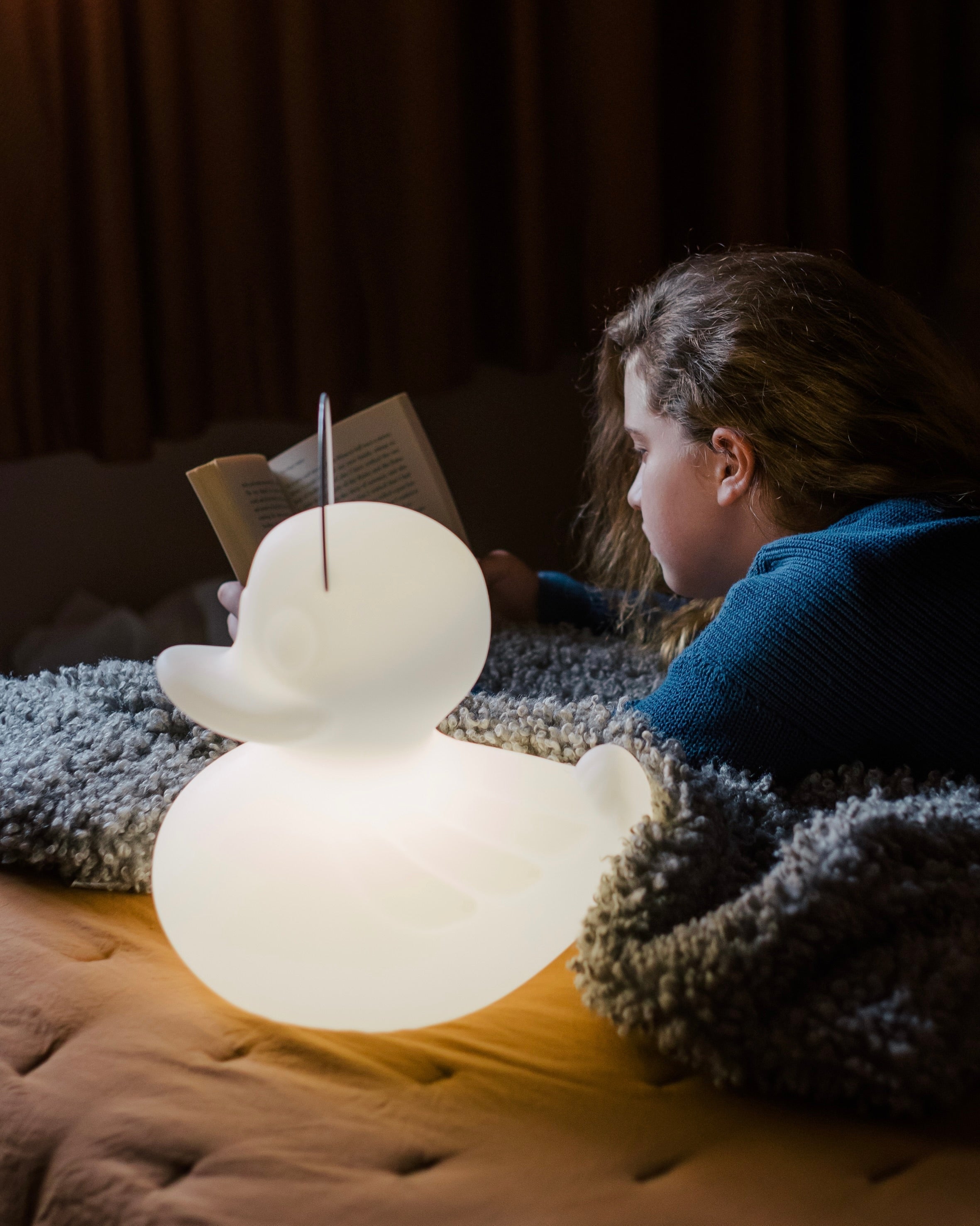 Goodnight Light lamp glowing softly in dark child's bedroom at night, dim night light setting